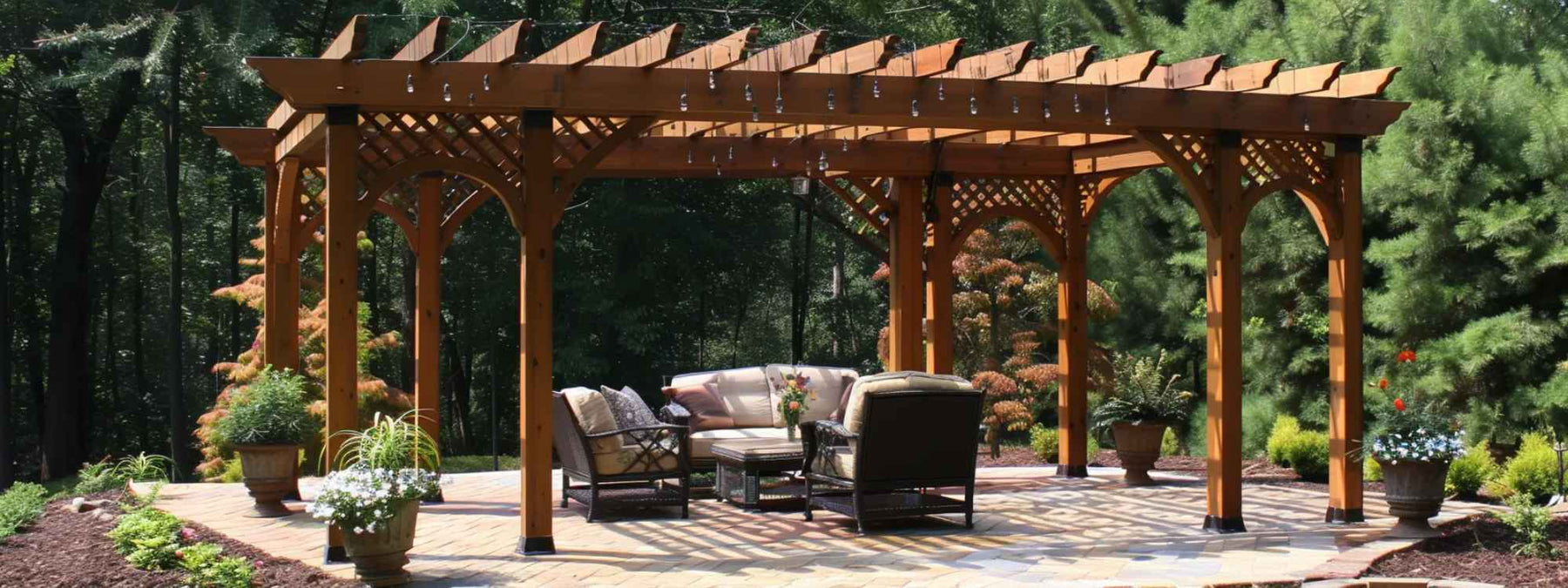 A large wooden pergola with lattice detailing stands over a patio seating area surrounded by trees, showing an ideal example for a guide on How to Maintain a Wooden Pergola