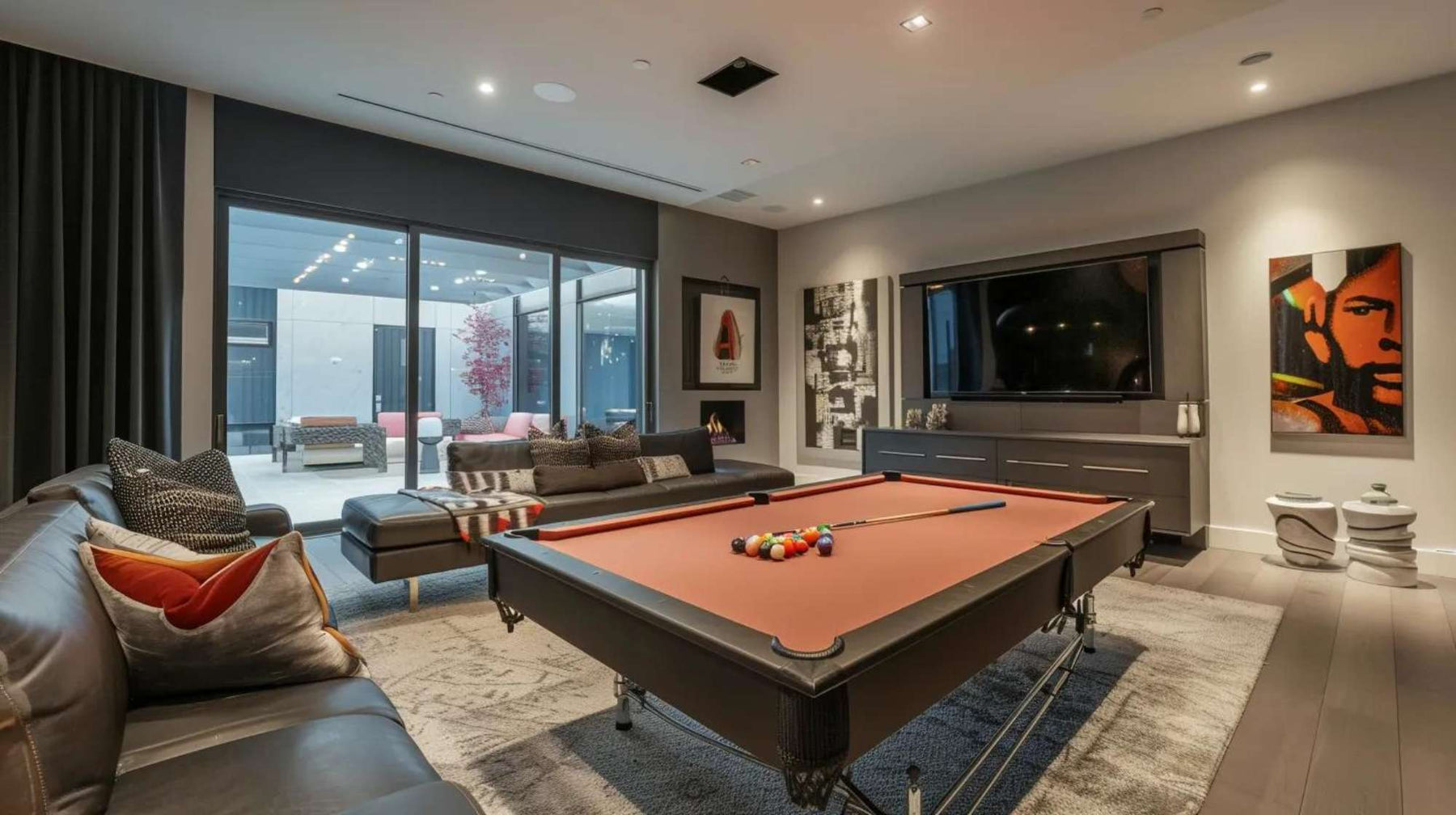 A stylish indoor lounge with floor-to-ceiling windows, a pool table centerpiece, and soft lighting—demonstrating How to Build the Ultimate Man Cave for relaxation and fun