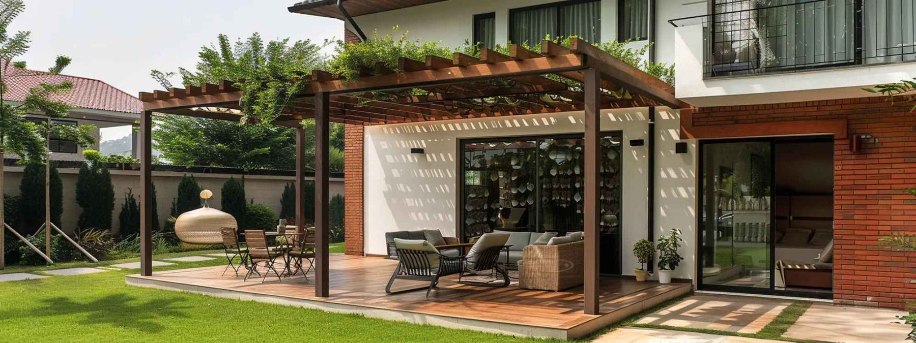 A wooden pergola extends from a modern house, showing how to build a pergola attached to the house with a shaded area for outdoor dining and seating