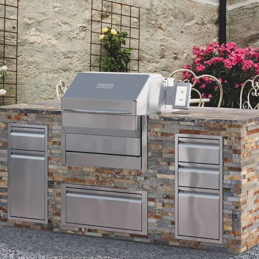 A Memphis Grills Pro Built-In ITC3 is built into a stylish stone outdoor kitchen, surrounded by modern stainless steel drawers and a touch-screen control panel