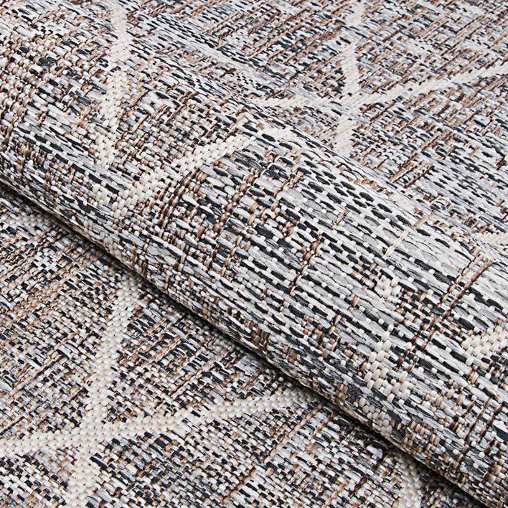 A detailed look at the rolled edge of the Couristan Charm Indoor/Outdoor Rug - Thicket/Twig showcases its textured surface and earthy pattern with a diamond design