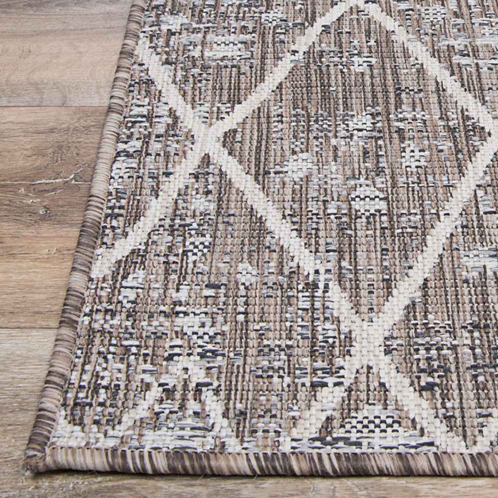 Corner view of the Couristan Charm Indoor/Outdoor Rug - Thicket/Twig captures its clean edge, subtle pattern, and natural tones on a hardwood floor