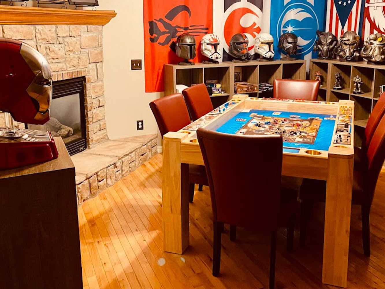 In a gaming-themed room, the Game Theory Tables Origins Lit Game Table takes center stage, set up for an intense board game