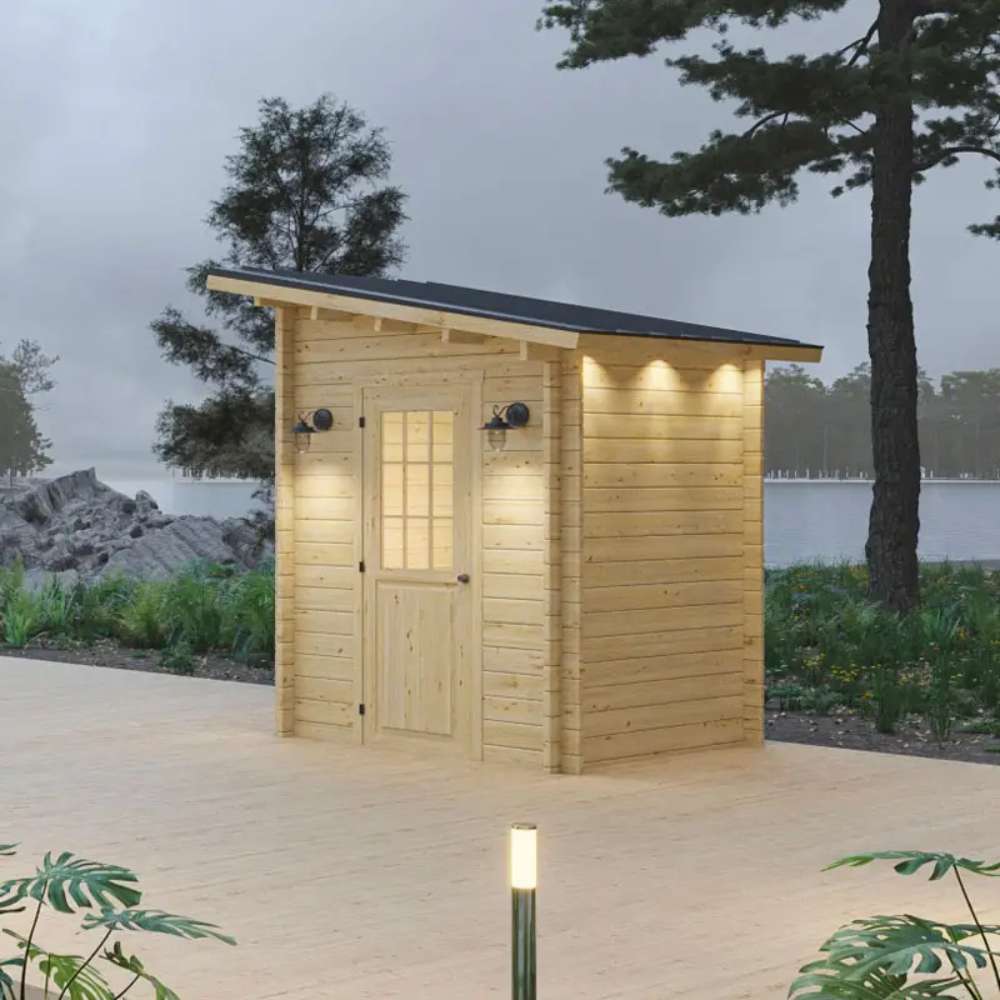Nestled by a lake, Sawmill Structures Loo Loo House Garden Room features a sloped roof, soft lighting, and natural wood construction surrounded by trees