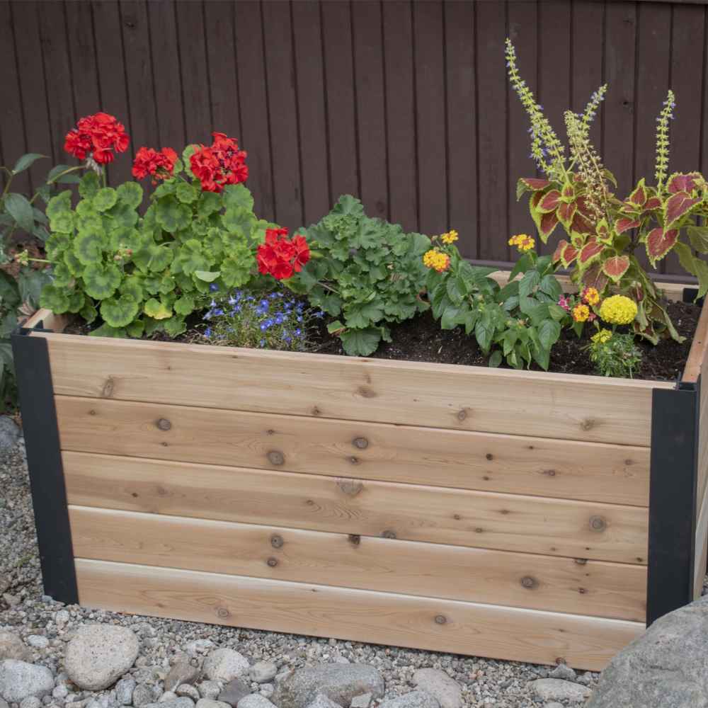 Outdoor Living Today 4×1.5 Urban Raised Garden Bed is filled with bright flowers and plants in a peaceful garden setting