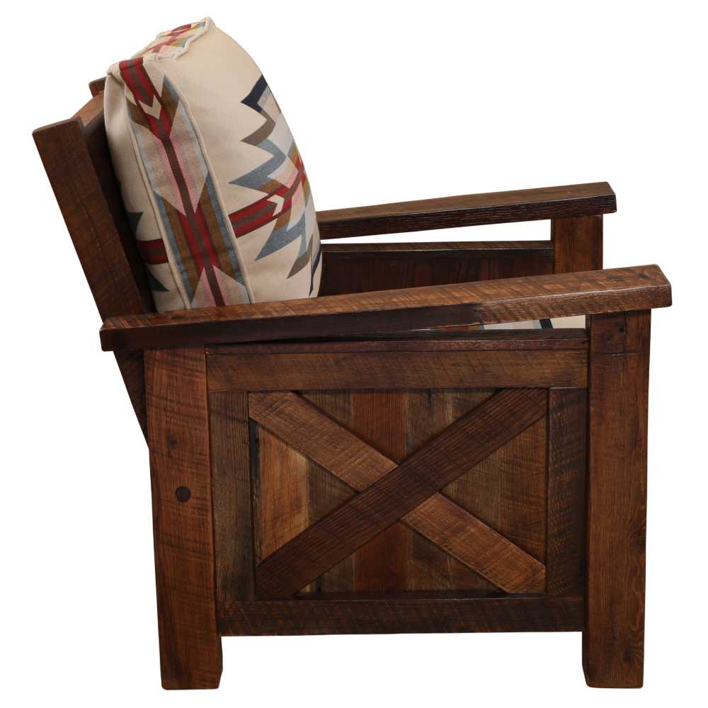 Side view of the Fireside Lodge Barnwood Lounge Chair displays thick wooden arms, a sturdy frame, and a patterned cushion in bold southwestern colors
