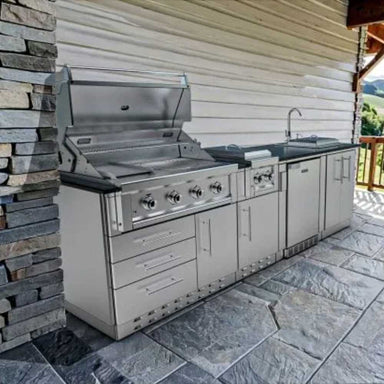 Sunstone Houston 9ft 8in Outdoor GrillBar Sink & Fridge Island Package is built into a patio nook with stone floors and walls, ready for backyard cooking
