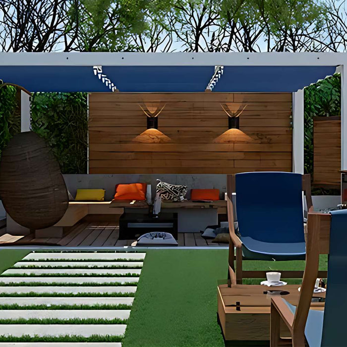 A hanging egg chair and outdoor lights add comfort and ambiance to a space surrounded by The Best Plants to Grow Around Your Pergola