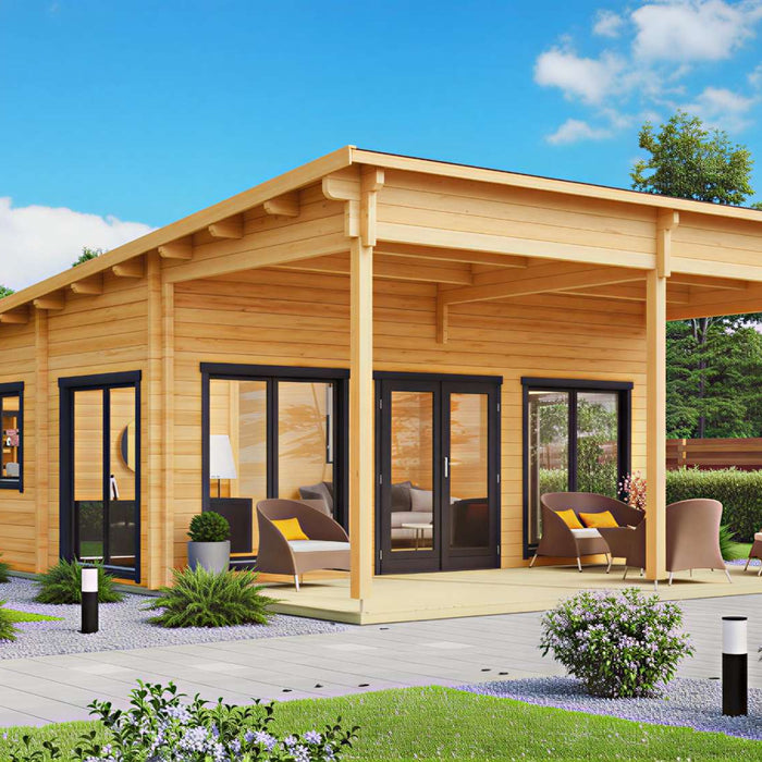 A modern wooden garden house for living with large glass doors sits in a sunny backyard surrounded by green shrubs and outdoor seating