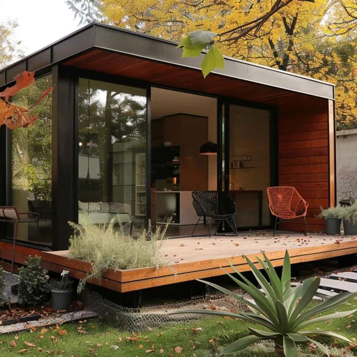 A modern wooden tiny home with large glass doors sits in a quiet autumn garden, helping illustrate what is the smallest livable tiny home