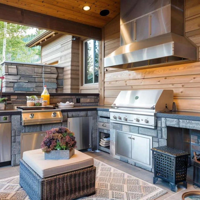 A stone and wood outdoor cooking area with built-in appliances and seating, showing what is an outdoor kitchen