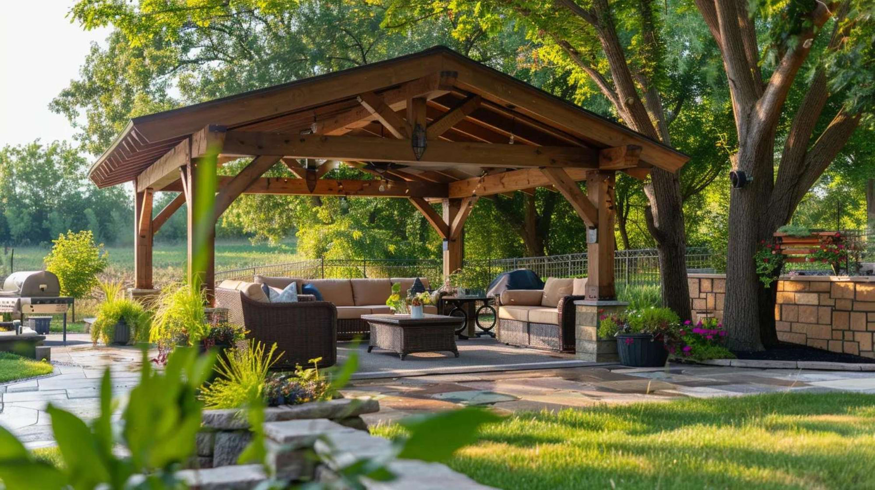 Backyard entertainment space with a wooden roof structure, cozy seating, and greenery to help homeowners design a pavilion that blends with nature