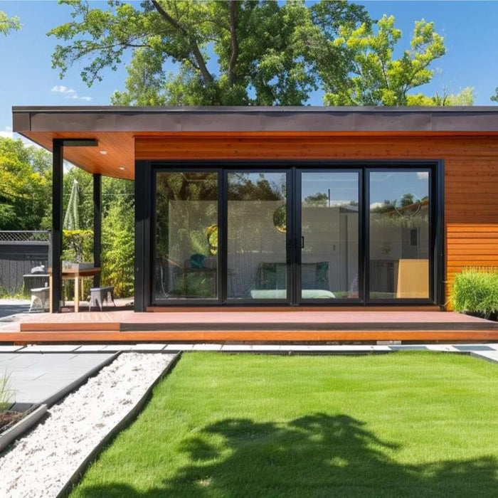 Modern flat-roof tiny home with large glass doors, wood siding, and a landscaped backyard patio, designed for tiny home passive income $2000