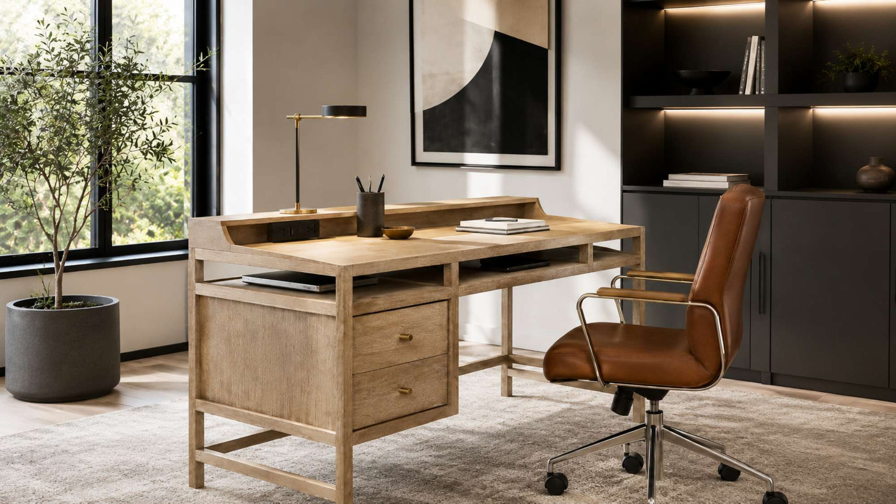Modern home office with a light wood desk with outlets, built-in drawers, a leather chair, dark shelving, and large windows