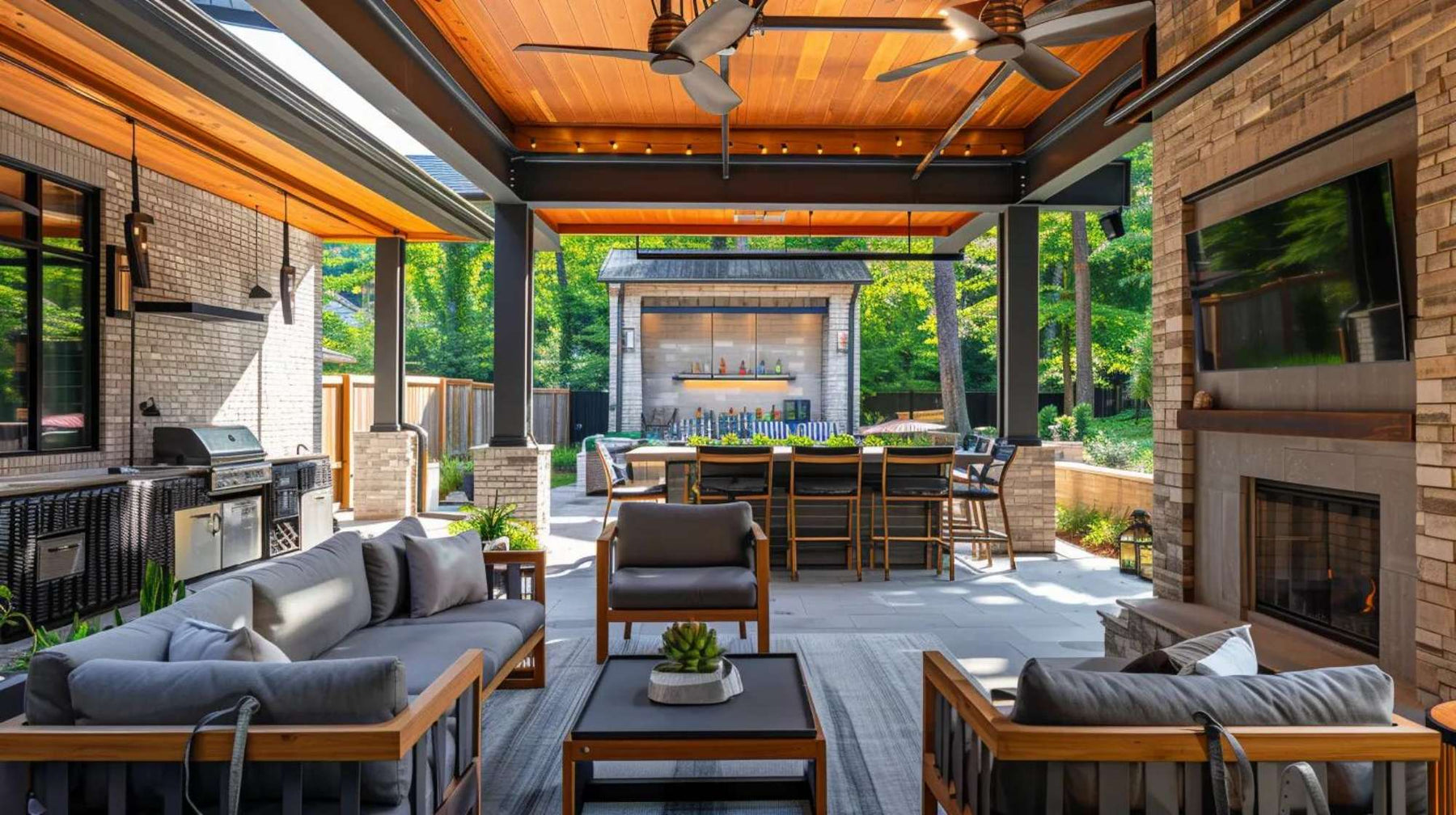 Modern outdoor living space with covered seating, outdoor kitchen, fireplace, and dining area for backyard entertaining