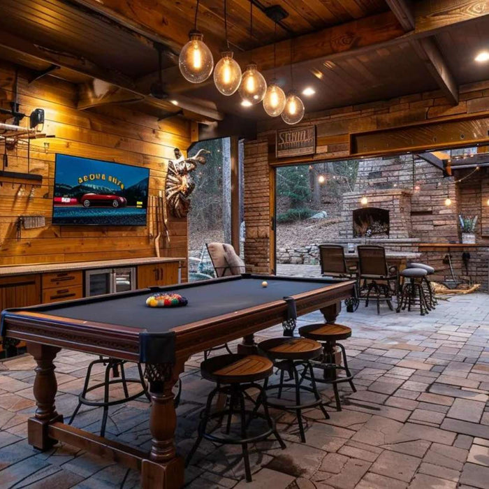 Outdoor man cave trends featuring a rustic game room with a pool table, TV, outdoor kitchen, and stone fireplace