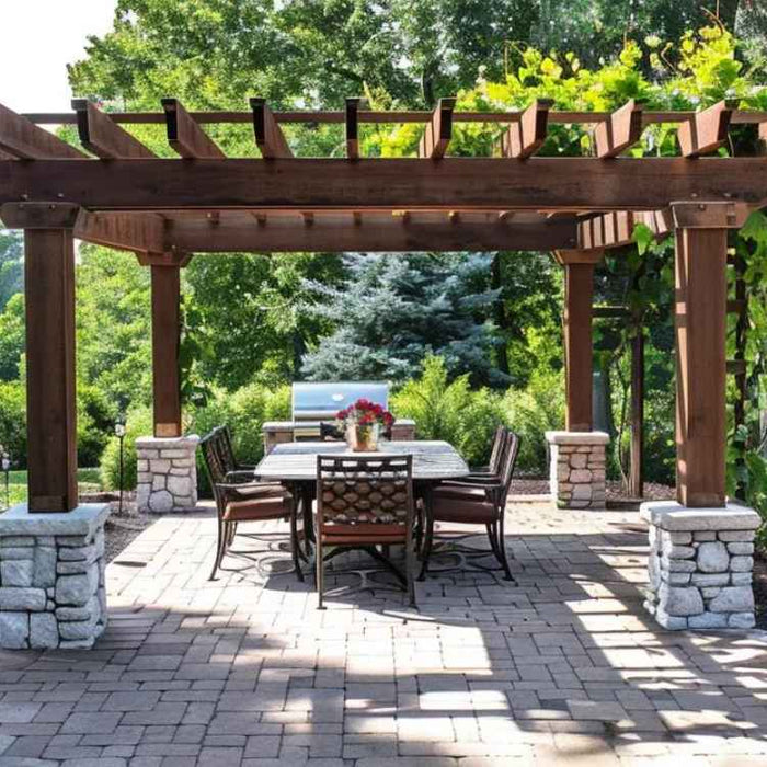 Surrounded by greenery, this pergola casts dappled shadows on a brick patio, helping illustrate how much shade does a pergola provide during daytime