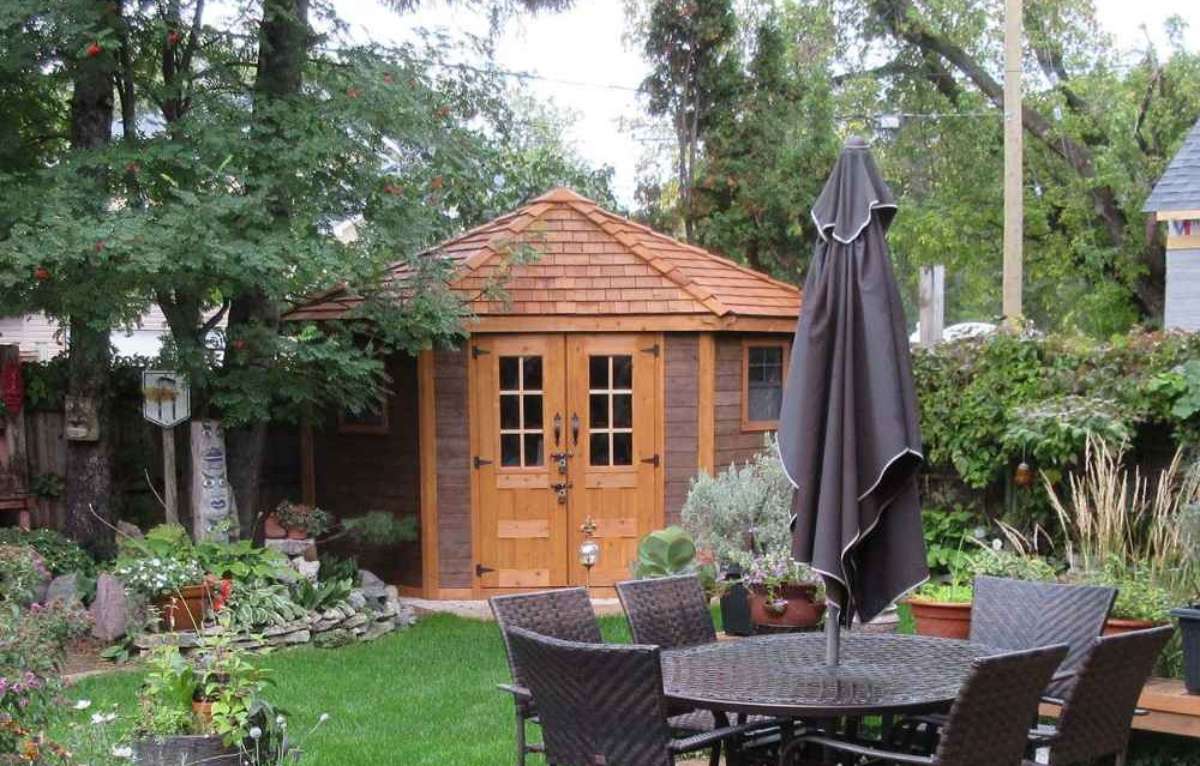 Wooden garden shed with double doors sits in a green backyard near patio furniture, a setup that often raises the question are sheds taxable