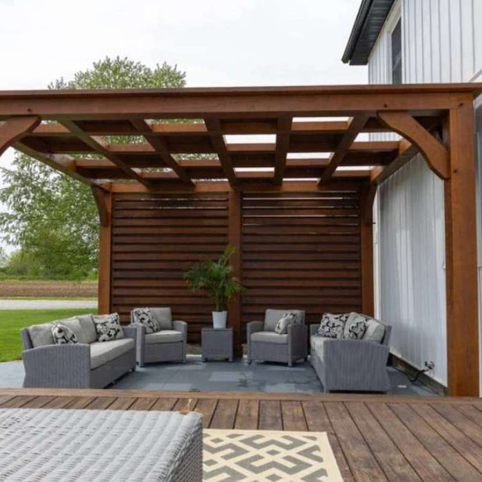 Wooden pergola attached to a house covers an outdoor seating area with sofas and privacy slats, helping answer do i need permission to put up a pergola