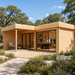 L-shaped light wood studio with glass doors, a porch, and two people working inside the Lasse 44B ALU Freedom Office.