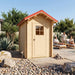 Small light wood outhouse with a red gabled roof and a windowed door, set in a desert landscape next to a pool.