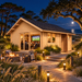 Small wood cabin at night with people inside, a fire pit, and a boardwalk path near the ocean. Melanie 70 Freedom Suite.