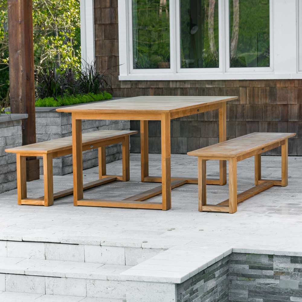 Westminster Teak Horizon Teak Dining Picnic Set on a patio near stone steps, planters, and house windows