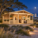 Glostrup 44 sports room illuminated at night among live oaks, maritime pines, sea oats, and coastal dunes on North Carolina’s Outer Banks.