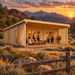 One light wood cabin with a covered porch and outdoor seating, set against a mountain landscape at sunset.