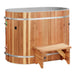 A cedar step sits in front of Golden Designs Dynamic Cold Therapy Oval Barrel Pacific Cedar Cold Plunge, an oval tub wrapped in vertical cedar staves and steel bands