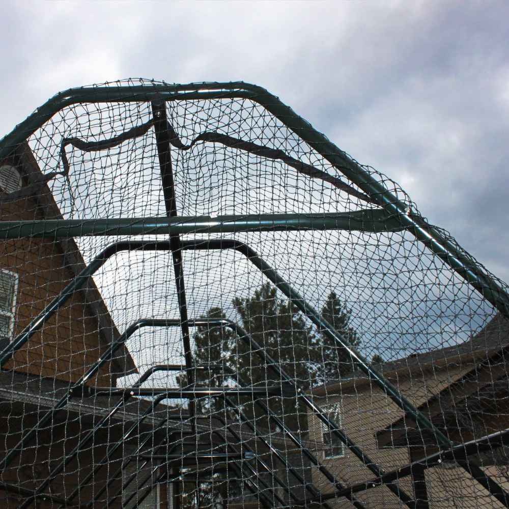 A close-up of the black mesh roof on Outdoor Living Today 8×12 Raised Garden Bed shows the frame arching over the garden against a cloudy sky