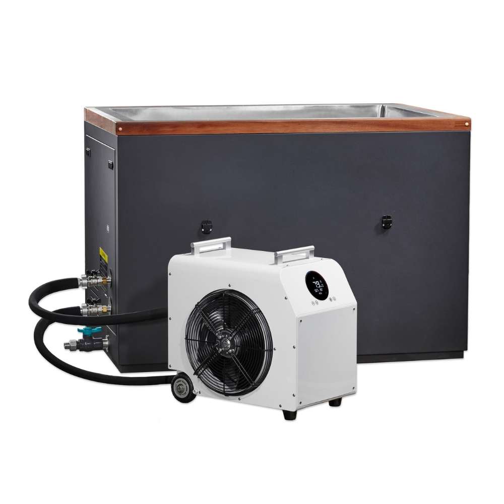 A white chiller with a large fan sits in front of Golden Designs Dynamic Cold Therapy Cuboid 304 Nano-Coated Stainless Steel Cold Plunge Tub XL, linked by black hoses to its side fittings