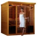 A woman in a white towel stands at the open glass door of Golden Designs Dynamic Monaco Elite 6 Person Ultra Low EMF Far Infrared Sauna