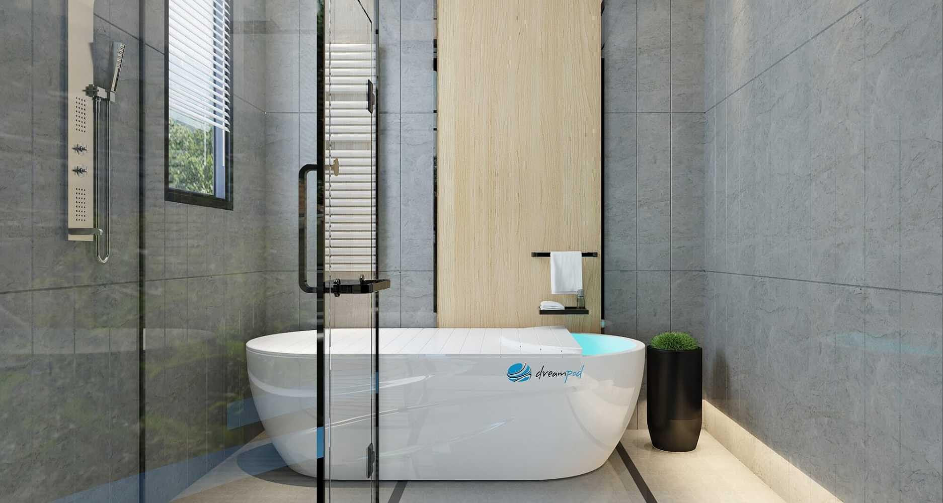 A Dreampod Home Float Pro tank is positioned in a bright, modern bathroom with a wood accent wall and glass shower