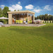 A stylish wooden structure with floor-to-ceiling glass walls stands on a sunny lawn with a dining table outside—this is the GardenHouse24 USA ALU Concept 70A Garden Room