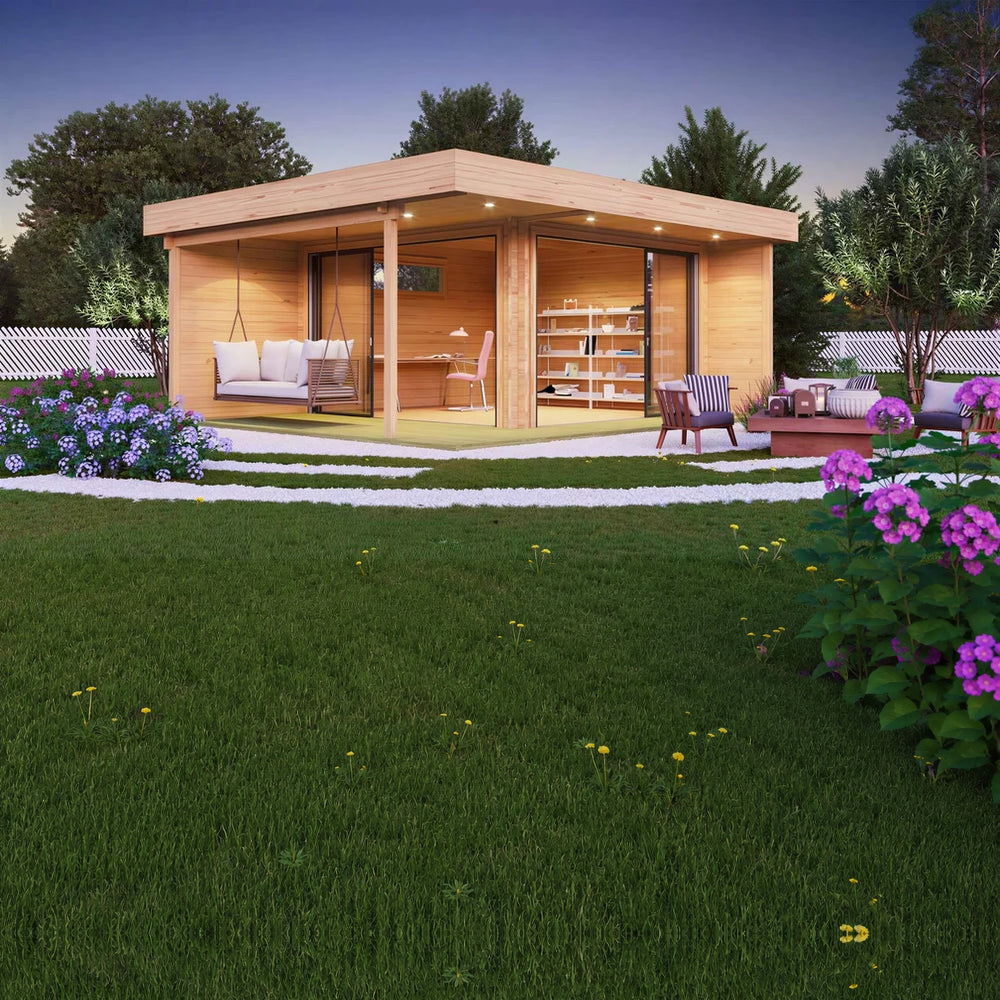 A cozy, modern GardenHouse24 USA ALU Concept Relax 70A Garden Room with large glass doors, a hanging chair, indoor office setup, and soft evening, with a grass lawn and lighting surrounded by blooming flowers.