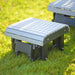 A LuxCraft Glider Footrest in dove gray and black sits on a grassy lawn