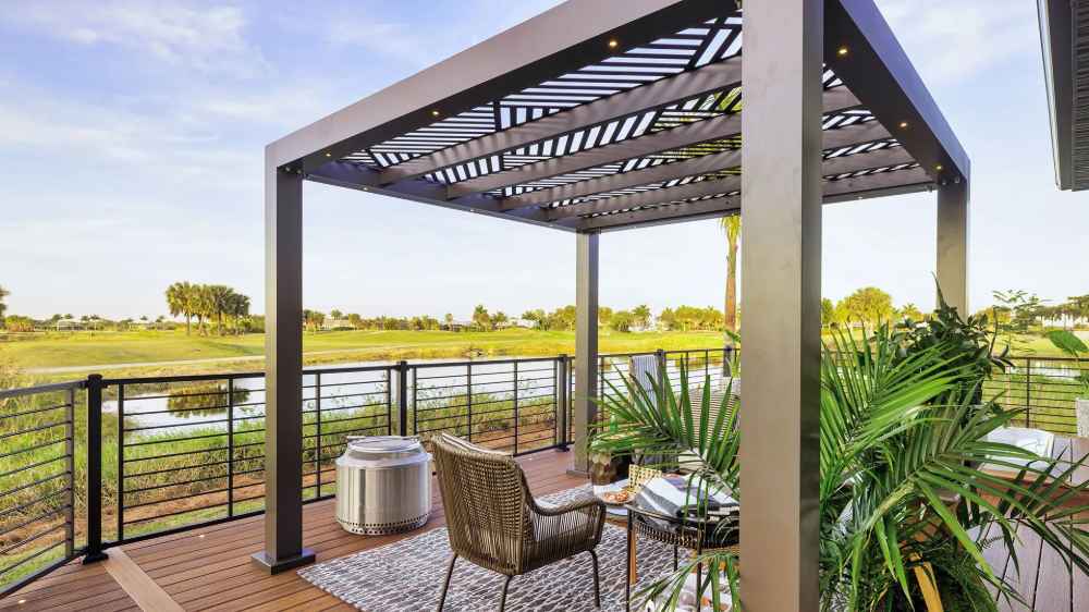 A Structureworks Shadow Trex Pergola with angular slats shades a serene outdoor balcony set for drinks