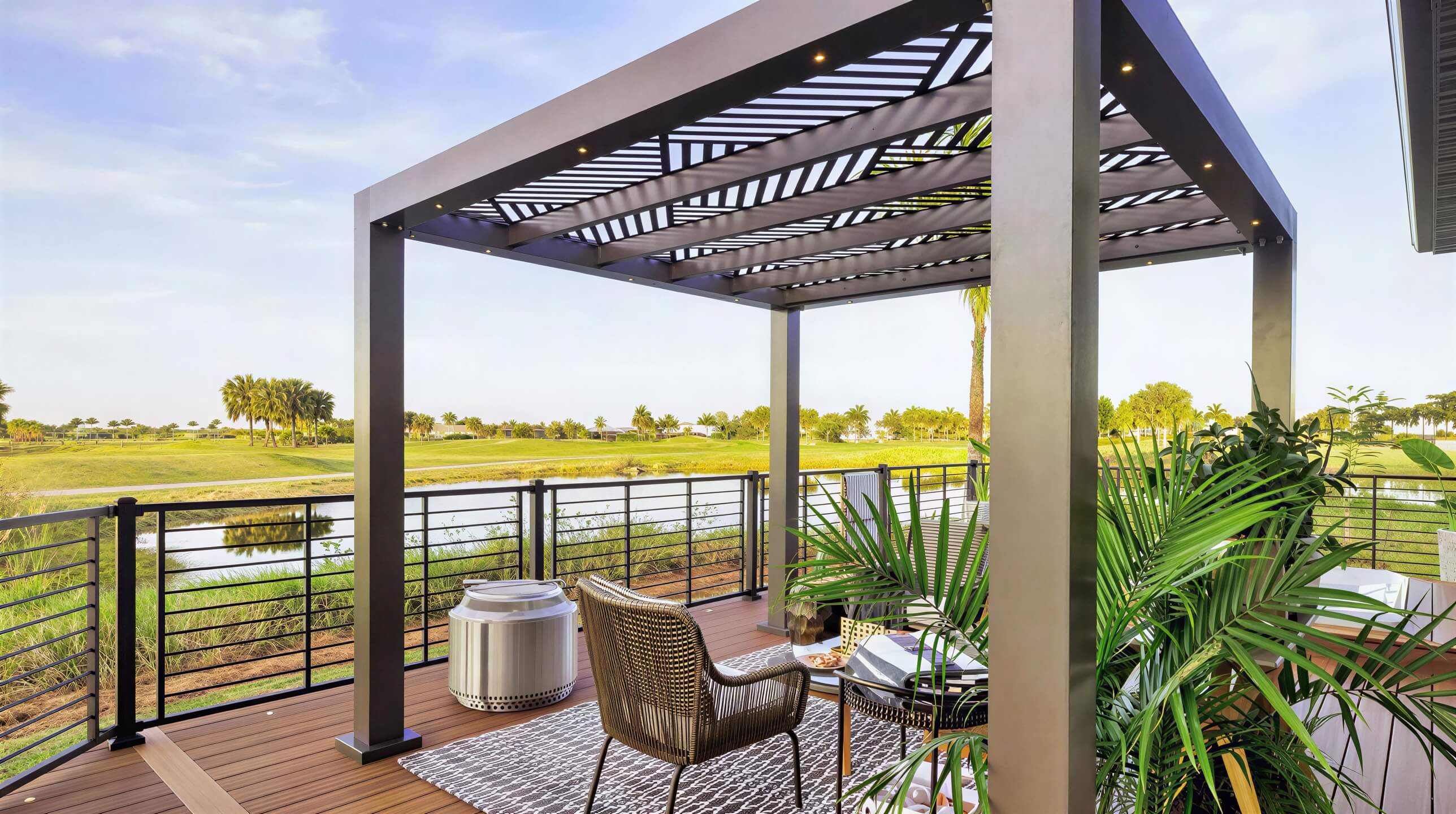 A Structureworks Shadow Trex Pergola with angular slats shades a serene outdoor balcony set for drinks