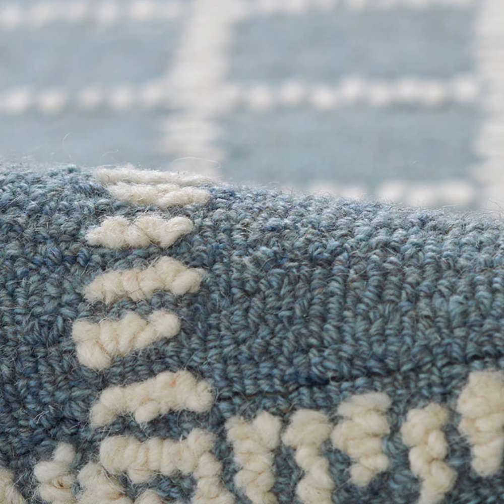 A close-up of Momeni Archer Indoor Rug - ARC-3 Blue reveals its textured wool surface and tightly woven white grid lines