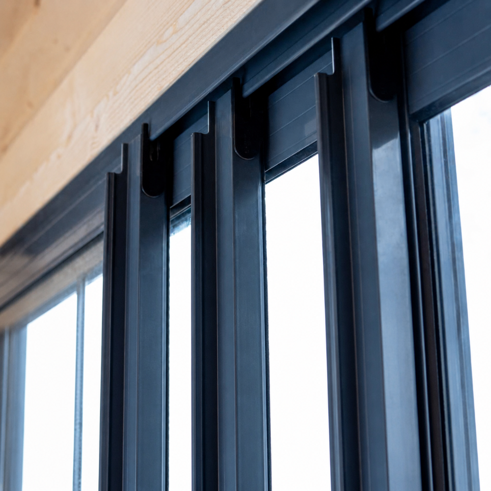 A close-up shows the sturdy aluminum track system for the sliding glass doors of the GardenHouse24 USA ALU Concept 44Q Garden Room

