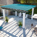A concrete patio with lounge chairs is shaded by a bright blue and gray Structureworks Trex Pergola with white columns