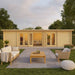 A cozy and modern backyard setup shows the GardenHouse24 USA Game Room 70 Garden Room with a wide glass front and a stylish outdoor lounge area in front