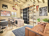 A cozy bar-style interior with leather seating, sports decor, and a modern liquor display is featured in this Sawmill Structures BlueWater Bungalow 160 Garden Room