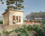 A cozy lakeside retreat showcases the Sawmill Structures The Versa 107 70MM Garden Room beside a firepit and four bold red chairs on a wooden deck