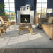 A cozy living room featuring Momeni Andes Indoor Rug - AND-8 Ivory adding warmth and texture beneath a modern wood coffee table