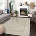 A cozy living room setup featuring a sofa, chair, and fireplace with Couristan Liguria Indoor/Outdoor Rug - Sarzana/Dove Grey as the centerpiece