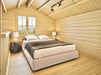 A cozy loft bedroom inside the Sawmill Structures BlueWater Loft 160 70mm Garden Room features a double bed under a sloped ceiling with natural wood walls and mountain views
