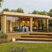 A cozy, modern seating and dining setup is shown inside the GardenHouse24 USA ALU Concept Lounge 44B Garden Room