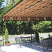 A cozy outdoor café area is shaded by a striped Structureworks Silhouette Aluminum Patio Cover & Pergola with sturdy black framing